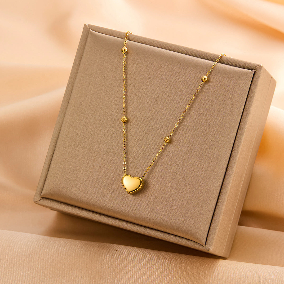 Collar de corazon dorado con esferas