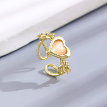 Anillo dorado ajustable con corazón rosa y detalles brillantes